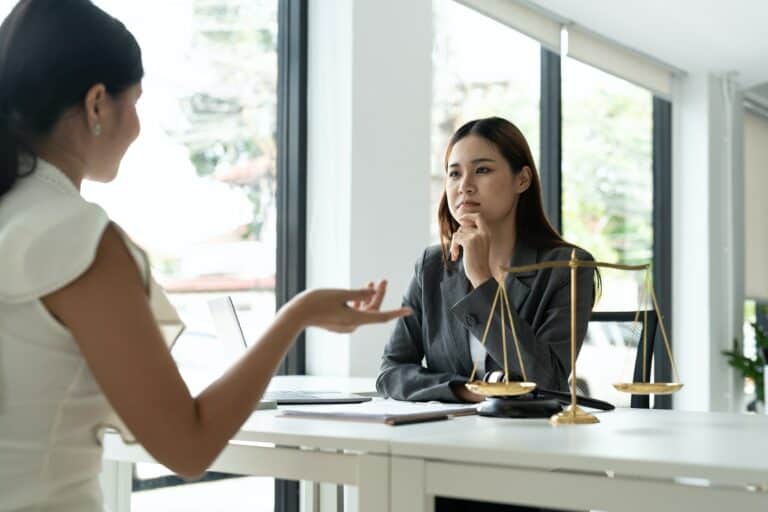 Asian female lawyer discussing negotiation legal case with client meeting with document contact in