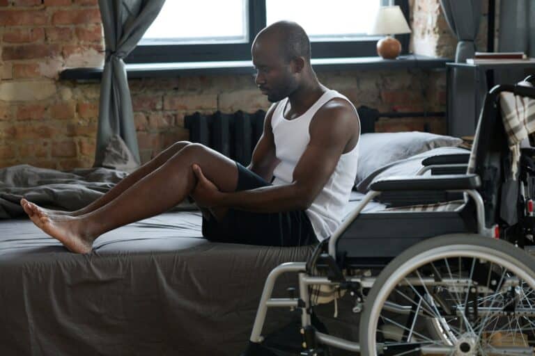 Man with disability standing up from the bed