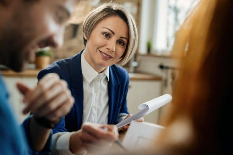 Smiling financial advisor talking to her clients during a meeting.