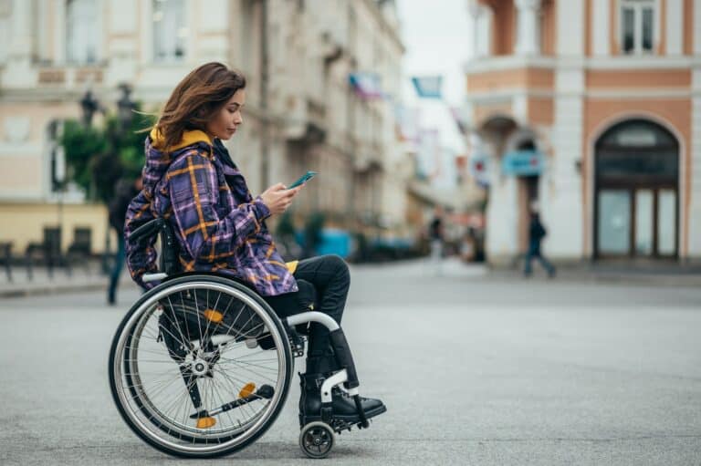 Woman with disability using a smartphone while out in the city